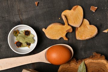 easter holiday still life and decorations, easter eggs, cookies in the shape of rabbit and heart on dark wooden background