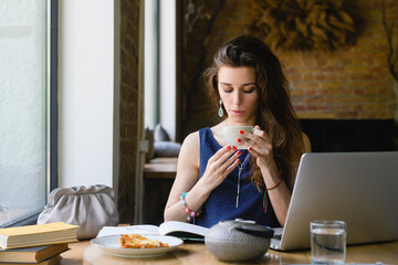 A young woman with a cup of tea in a coffee shop.
