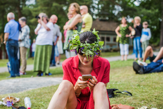 Woman with flower crown using smart phone