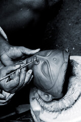 Creating clay head of goddess Durga in Kumartuli, Calcutta, India. The idols are made for the Hindu festival of Durga Puja also known as Dassera