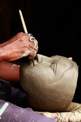 Creating clay head of goddess Durga in Kumartuli, Calcutta, India. The idols are made for the Hindu festival of Durga Puja also known as Dussehra