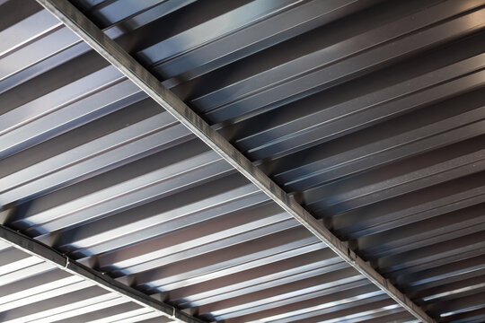 Iron structure, roof covered with corrugated aluminum sheets on metal supports. Background for images, space for design or decorations.