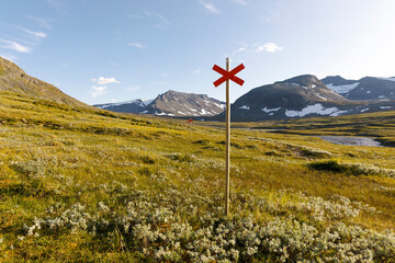 Red cross sign on hiking trail in Jamtland Sweden