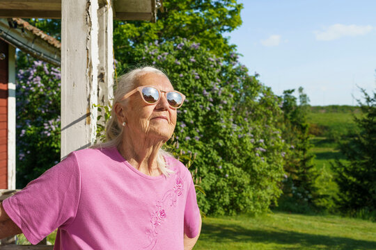 Senior woman with sunglasses at porche