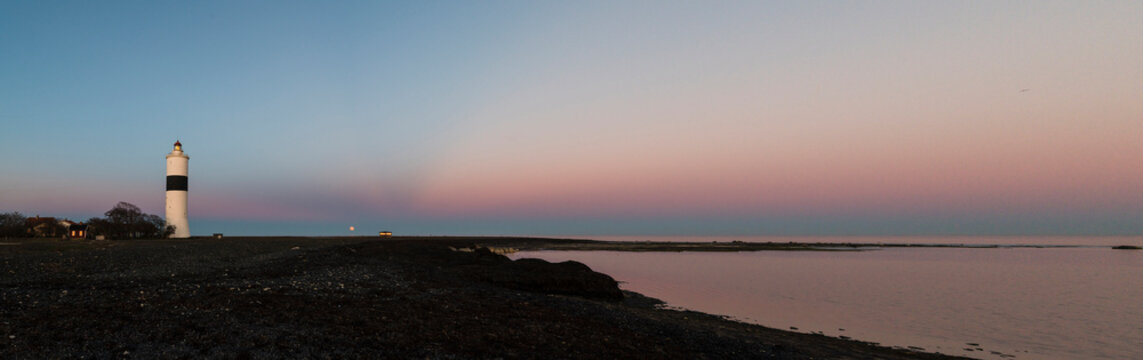 Lighthouse on coast at sunset