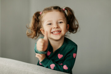 Portrait of a charming little girl with two ponytails, joyful and smiling