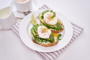 Freshly made poached egg and Avocado toasts on light grey background