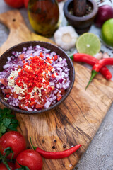making salsa dip sauce - chopped garlic, tomatoes and onion in wooden bowl