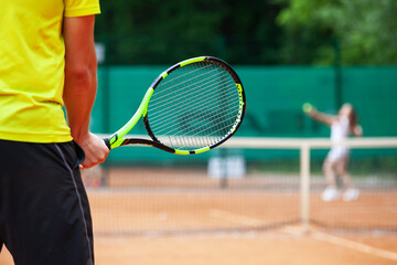 Midsection of male tennis player holding the racket.
