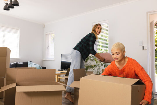 Image of happy diverse lesbian couple moving into new house - Powered by Adobe