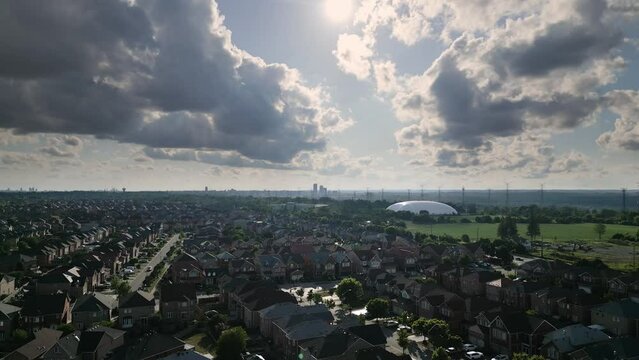 A wide drone shot of a suburban town (Markham Ontario), sunny and cloudy, jibbing from high to low.