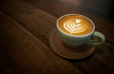 Cappuccino with latte art on wooden background. 