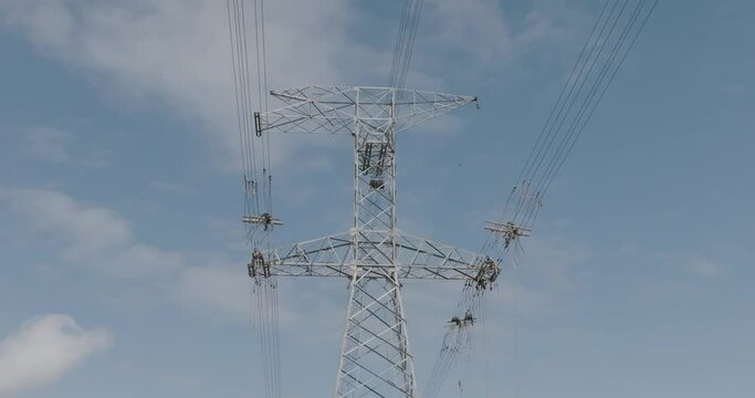 Low angle shot of unrecognizable workers on overhead power line. Aerial circling