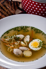 Soup with boiled eggs, noodles, chicken meat, parsley