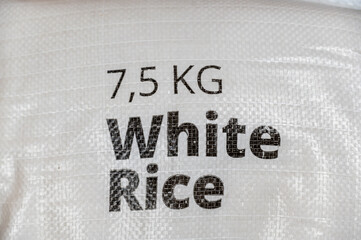 Bag of white rice. The black lettering on the white bag indicates the weight and type of product. Food and Grocery Products. Selective Focus.