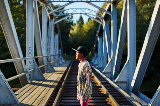 Boy in baseball cap on bridge
