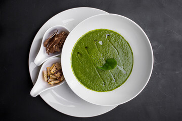 Soup with pea sauce, basil, cheese, sesame seeds and croutons