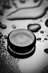 Black and white minimal motion blur image. Rotating round sphere on wet surface.