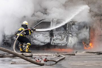 firefighter extinguishes a burning car
