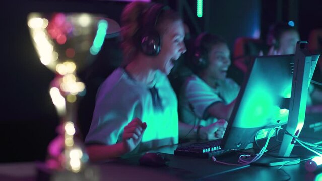 Handheld, female gamers in headphones, plays a video game, cyber sportsmans at the game, communication between players, the team won the round, emotions of victory, tournament.