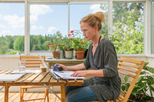 Woman working from home in sunroom