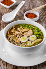 Soup with boiled egg, noodles, salad, green onions, and sesame seeds