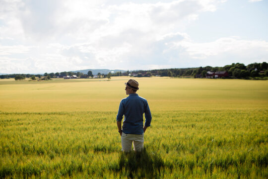 Young man in hat standing in field