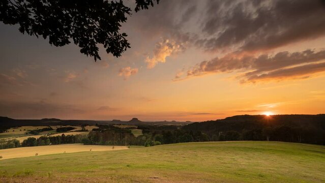 Abends im Elbsandsteingebirge: Ziehende Wolken und die untergehenden Sonne zaubern ein faszinierendes Lichtspiel. Der Blick wandert am Horizont &uuml;ber die zauberhafte Landschaft der S&auml;chsischen Schweiz.