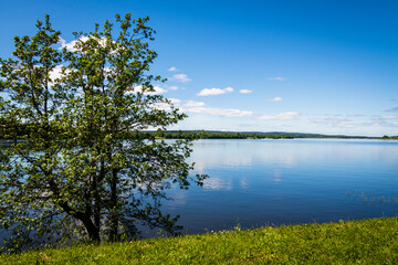 Landscape overlooking the lake on a clear sunny day. Lake Onega with the embankment of the Kizhi Island, Karelia, Russia. The concept of tourism in Russia.