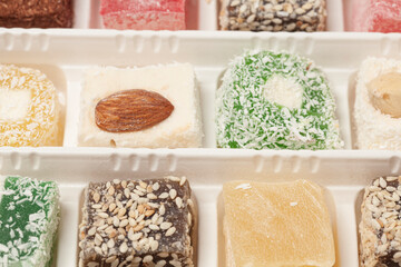 Cubes of traditional oriental sweets on a marble background, top view.