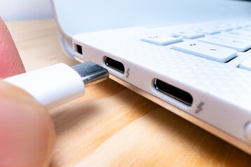 Close-up macro view of plugging USB type C cable into computer port - 516919971