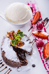 Chocolate fudge with raspberries, strawberries, basil, chocolate, and a scoop of ice cream