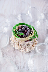 White dessert with cream crumbs, frozen currants and green chocolate