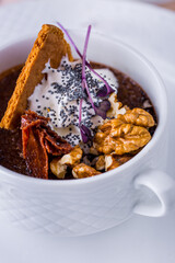 Dessert in a cup with walnuts, pastries, cream and poppy seeds
