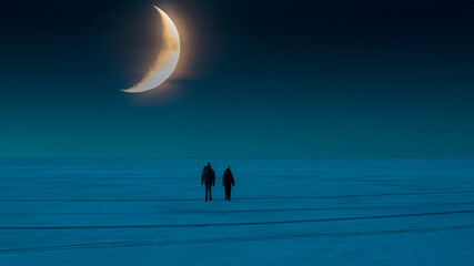 The two people walking through the snow field on the night sky background