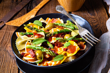 Pasta salad with green asparagus, olives and parma ham