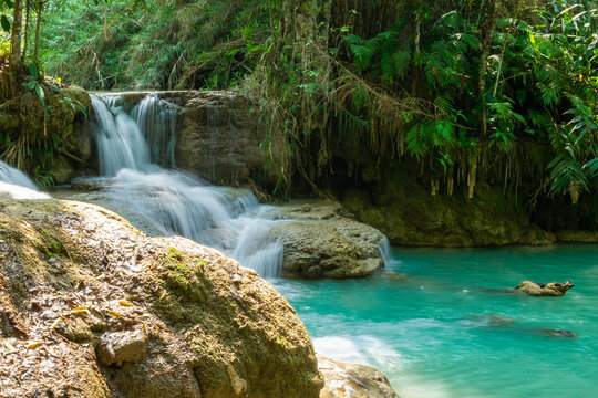 Beautiful waterfall in the tropical jungle. Emerald green waters in the forest. © silapin