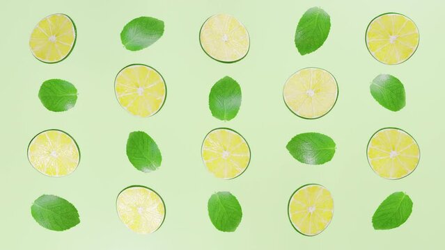 Many bright mint leaves and lime slices rotate on a light background.