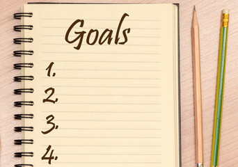 Top view notebook write message Goals and number list with pencil on table