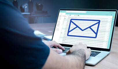 Businessman hand on keyboard laptop with icon E-mail on display