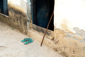 image of village house door with walking stick and a pair of sleeper