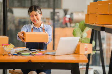 Asian owner, independent, SME business, online shopping Work on a laptop computer with a parcel box. Concept and delivery of an online SME business