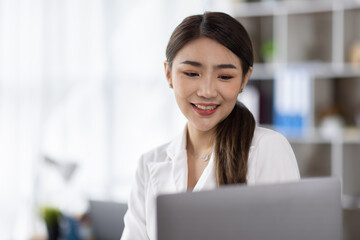 Business of Asian woman or accountant working on calculator to calculate business data, accounting document, and laptop computer at home office, business finances and calculate concept