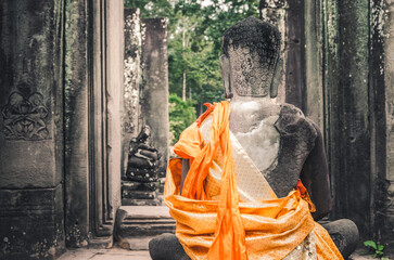 Stone statue of a seated Buddha in a temple in Cambodia.