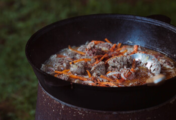 Recipe for traditional oriental pilaf in a cauldron in nature. Cooking. Recipes. Step-by-step photo...