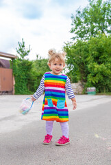 The child draws with chalk on the pavement. Selective focus.