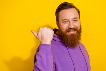 Profile photo of positive man indicate thumb finger empty space isolated on yellow color background