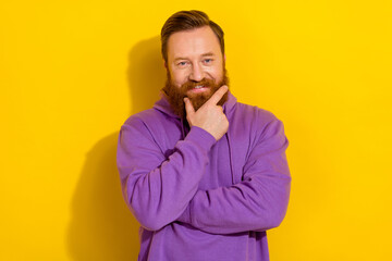 Photo of pretty smart man wear violet sweatshirt arm chin smiling isolated yellow color background