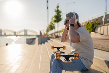 hipster skater man smiling happy using headphones at the street.
