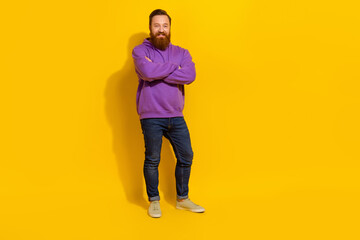 Fototapeta na wymiar Full length photo of cool confident man wear violet sweatshirt arms crossed empty space isolated yellow color background